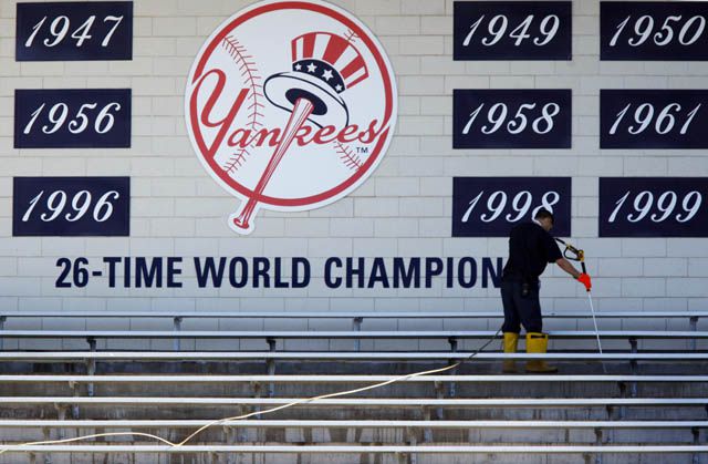 A worker cleans the bleachers at Yankee Stadium in preparation for game 1 of the ALDS.